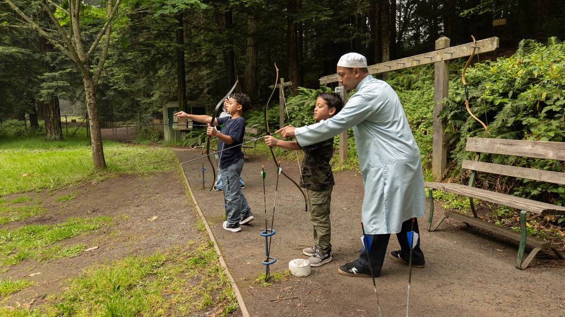 An instructor mentoring a young archer